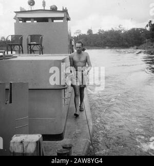 [Patrol boat on a river. A man in shorts running along the side of the ship] Date: 01/01/1947 Location: Indonesia Dutch East Indies Stock Photo