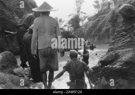 Action 4-4 Battalion Hunters in Magetan, East Java  Operation Clean Ship. Patrol passes through a watercourse Date: March 29, 1949 Location: Indonesia, Java, Dutch East Indies Stock Photo