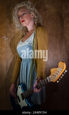 Woman playing electric guitar, vintage grunge Grunge rock style setting Stock Photo