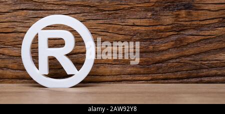 Registered Trademark Sign Leaning On Wooden Wall Stock Photo