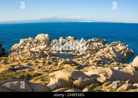 bizarre rocks at Capo Testa, Sardinia, Italy, in the background Corsica, France Stock Photo