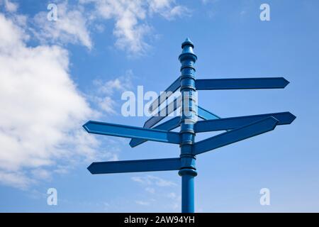 Blank signpost multiple directions against a blue sky Stock Photo