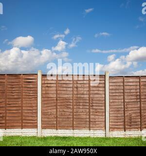 Garden fence wooden panels with a blue sky above Stock Photo