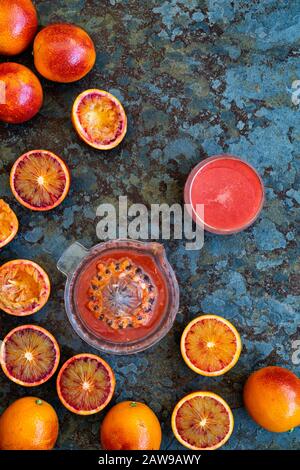 Juicing blood oranges. Blood orange juice and blood oranges on slate Stock Photo