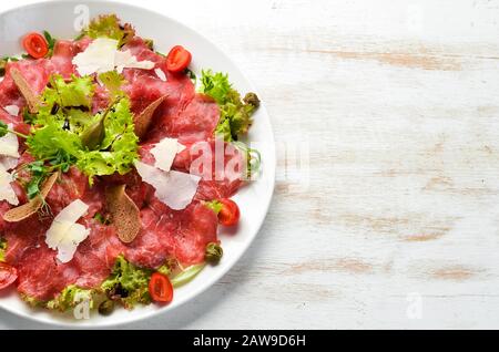 Veal carpaccio. Veal with capers and parmesan cheese. Top view. Free copy space. Stock Photo