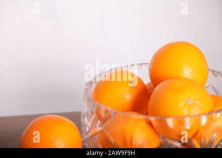 Lead crystal fruit bowl full of oranges 'fruit' against white background with copy space Stock Photo