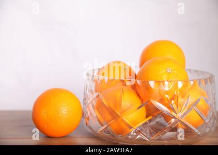 Lead crystal fruit bowl full of oranges 'fruit' against white background with copy space Stock Photo