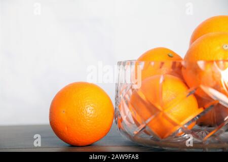 Lead crystal fruit bowl full of oranges 'fruit' against white background with copy space Stock Photo