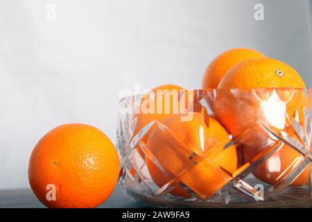 Lead crystal fruit bowl full of oranges 'fruit' against white background with copy space Stock Photo