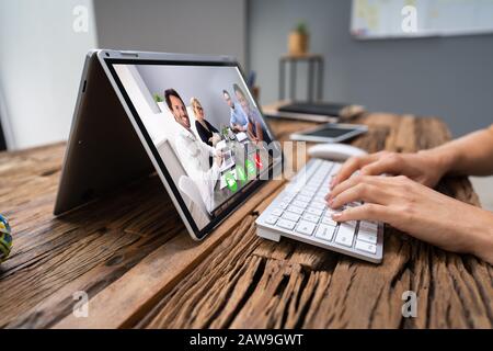 Businesswoman In Video Chatting With Her Colleagues On Laptop Stock Photo