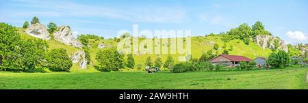 Rural panorama - farm at the impressive rocks of valley Eselsburger Tal near river Brenz - jewel of the swabian alps, meadow in front Stock Photo