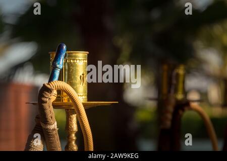 Part of hookah, traditional arabic waterpipe, in the arabic restaurant. Horizontal, direct sunset light, outdoor photo Stock Photo