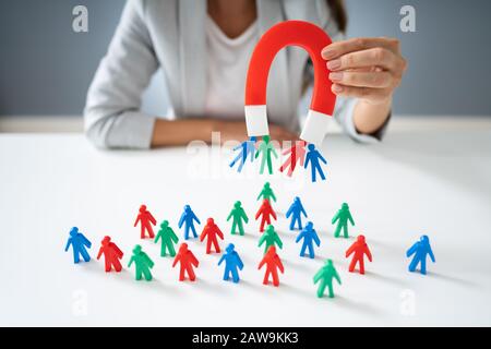 Businessperson Attracting Human Figures With Horseshoe Magnet Stock Photo