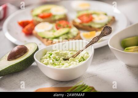 Avocado spread guacamole toasts egg tomato chives as breakfast meal or appetizer Stock Photo