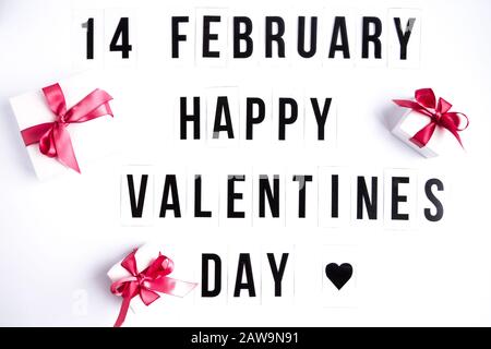14 february, Happy valentines day text on white table background, with gift boxes Stock Photo