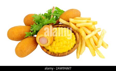 Mini party corn dogs on wooden sticks and French fries with a wooden bowl of American mustard isolated on a white background Stock Photo