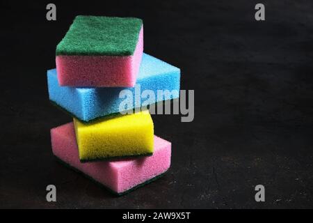 Foam sponges of different colors on a dark background Stock Photo
