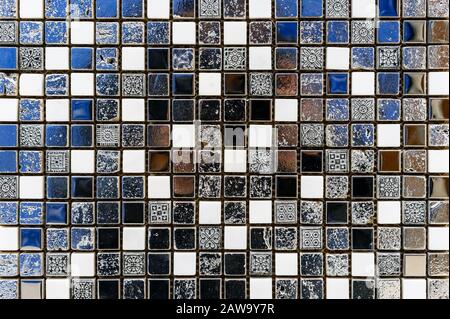 Ceramic mosaic tile in antique style with white, black and blue squares. Stock Photo