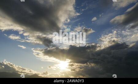 Stormy clouds with sun shining. Dramatic rain clouds. Stock Photo