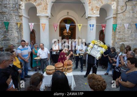 Akamatra, Ikaria, Greece: the priest blesses the loaves of bread for the Feast of the Assumption of the Virgin Mary on 15th August Stock Photo