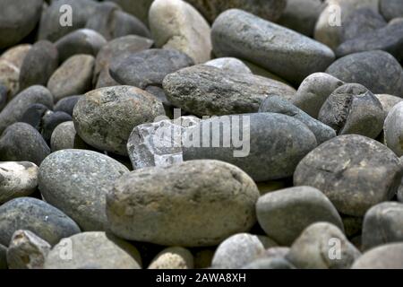 Different in shape and color gray beige rounded stones. Stock Photo