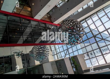 Metal chandelier hanging of the glass ceiling in lobby of Avaz Twist Tower skyscraper headquarters for Dnevni avaz,a Bosnian newspaper company.Sarajev Stock Photo