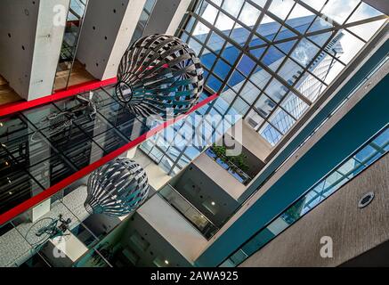 Metal chandelier hanging of the glass ceiling in lobby of Avaz Twist Tower skyscraper headquarters for Dnevni avaz,a Bosnian newspaper company.Sarajev Stock Photo