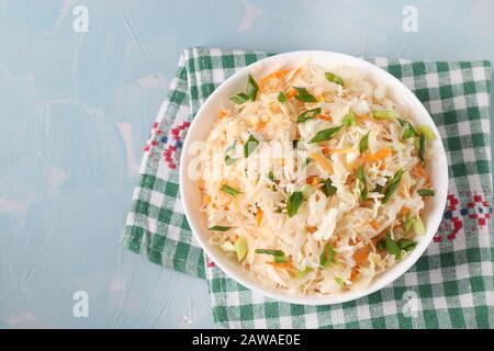 Fermented food, Homemade Sauerkraut with carrots and green onions in a bowl on a light blue background, Top view, Flat lay Stock Photo
