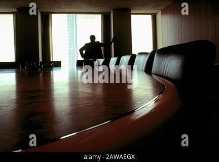 Executive looks out of a boardroom window. Stock Photo