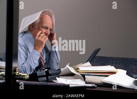 Stressed businessman with too much paperwork Stock Photo