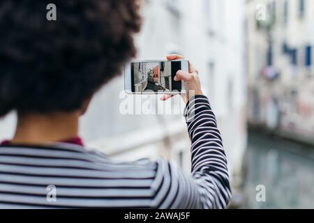 Young woman taking picture with mobile phone Stock Photo