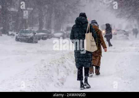 Montreal, CA - 7 February 2020: Pedestrians walking on Monkland Avenue during snow storm. Stock Photo