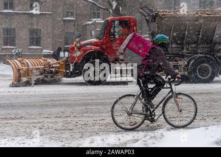 Montreal, CA, 7 February 2020: Man riding bike in Downtown Montreal during snow storm Stock Photo