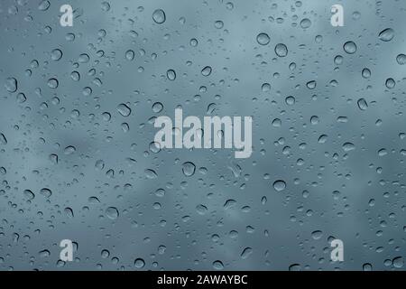 Raindrops on the window close up. rain drops on the glass macro. water drops falling down on window. rainy day. wet glass. raindrops trickle down Stock Photo