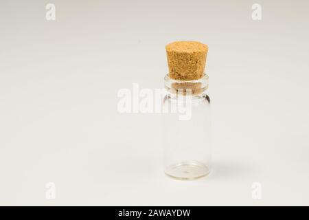 Empty little bottle with cork stopper isolated on white. glass vessel. transparent container. test tube. copy space Stock Photo