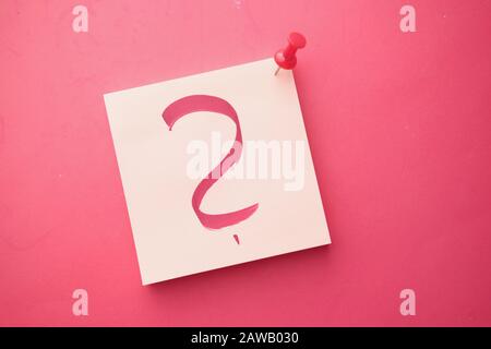 question mark on notepad on red background, top view  Stock Photo