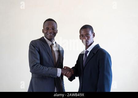 Black Businessman working in his office looking happy in suit and tie Stock Photo