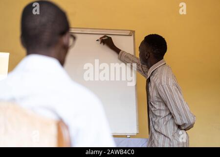 Black African Ethnic Man Showing his Employees a Company Project on a whiteboard Stock Photo