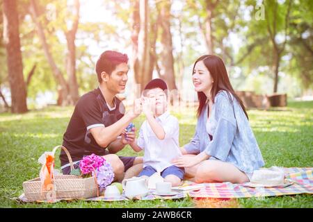 young family playing with child kid outdoor park lovely lifestyle and living with nature Stock Photo