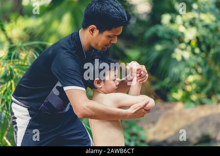 Parent teaching boy or son for self dense guard stand and kick boxing for strong and healthy kid. Stock Photo
