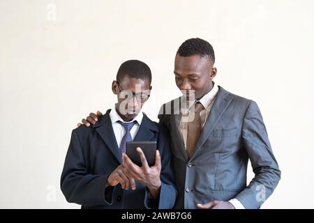 Couple of African Black Businessmen Working together on Modern Future Technological Tablet Stock Photo