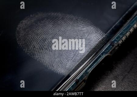 Close-up of realistic glossy smart phone electronics device screen with fingerprint dirt residue above in-screen reader Stock Photo