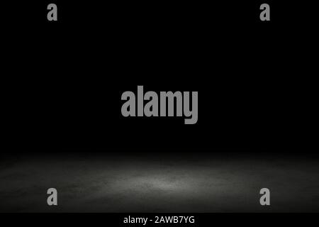 Light shining down on black marble floor in dark room with copy space, abstract background Stock Photo