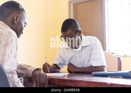 Technology symbol for the African startup and youth: two African people working together in an office Stock Photo