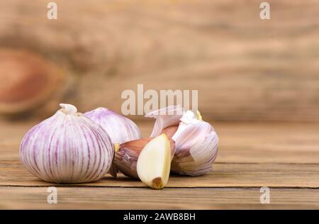 Several heads of garlic on a wooden background. Rustic style. Copy space. Stock Photo