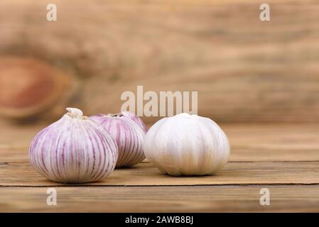 Several heads of garlic on a wooden background. Rustic style. Copy space. Stock Photo