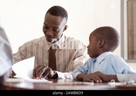 Candid authentic photo of Handsome African father and cute son for the first day of school or adoption symbol Stock Photo