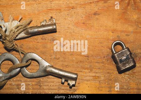 Old keys with small lock isolated on wooden background. safety and security concept Stock Photo