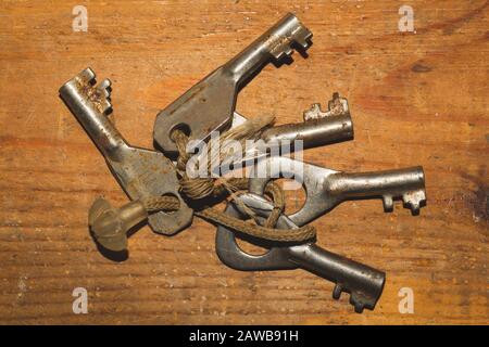 Bunch of old keys isolated on wooden background. safety and security concept Stock Photo