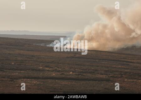 Gamekeeper using controlled heather burning as part of the grouse moor management. North Yorkshire Moors, England, UK, GB. Stock Photo